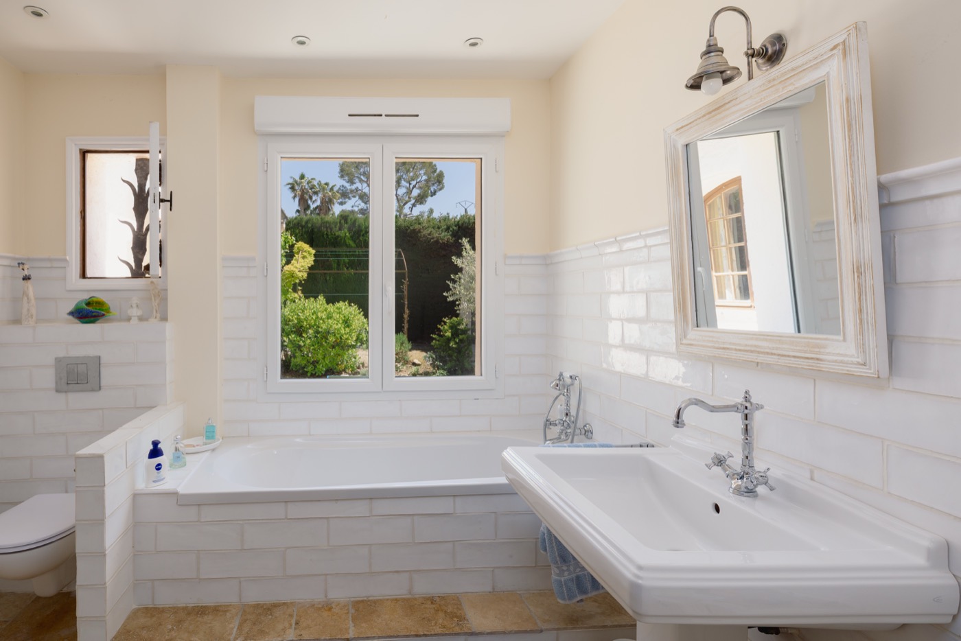 Helles Badezimmer mit Badewanne und Gartenblick